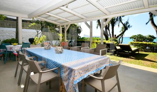 a table and chairs on a patio with the ocean at Villa Cap Malheureux in Cap Malheureux