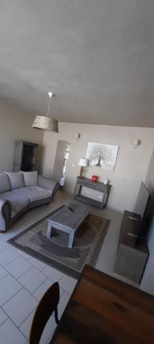 un salon avec un canapé et une table dans l'établissement Maison de ville, à Kergrist