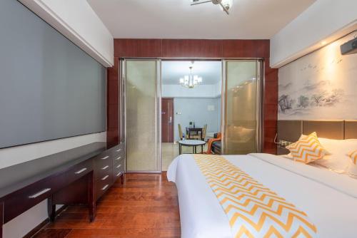 a hotel room with a bed and a tv at 寓洣公寓佛山铂顿祖庙岭南天地店 in Foshan
