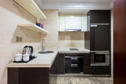 a kitchen with a sink and a microwave at 寓洣公寓佛山铂顿祖庙岭南天地店 in Foshan