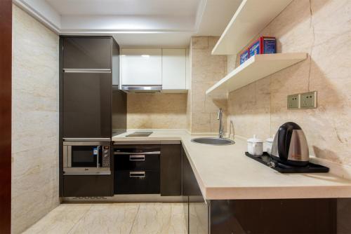 a kitchen with a black refrigerator and a sink at 寓洣公寓佛山铂顿祖庙岭南天地店 in Foshan