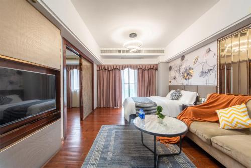 a living room with a couch and a tv at 寓洣公寓佛山铂顿祖庙岭南天地店 in Foshan