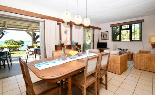 a dining room and living room with a table and chairs at Villa Cap Malheureux in Cap Malheureux