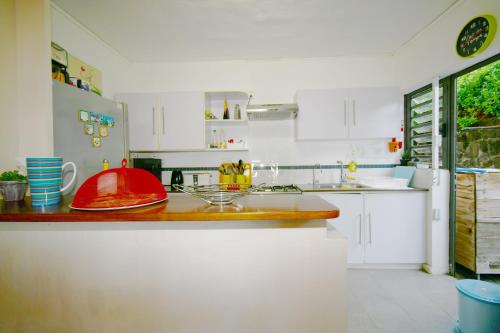 a kitchen with white cabinets and a red bowl on a counter at Villa Cap Malheureux in Cap Malheureux