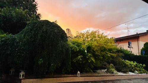 a sunset over a garden with trees and a building at BBSUITE21 Maranello in Maranello