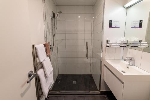 a bathroom with a shower and a sink at 315 Euro Motel and Serviced Apartments in Dunedin