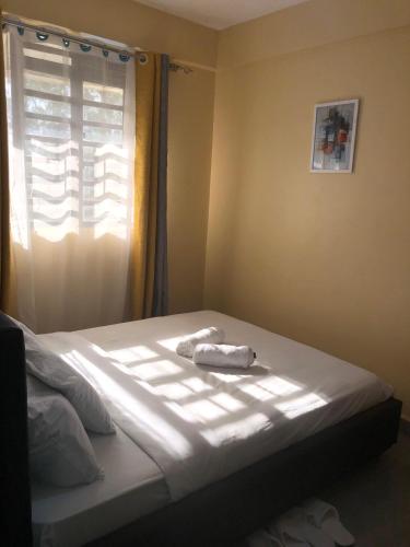 a bed with a towel on it in a bedroom at Kisumu Airview Homestay in Kisumu