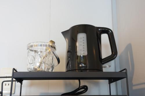 a black coffee maker and a blender on a shelf at IG3 宇佐美駅近海近の完全貸切ビーチハウス お宿三感四温 Oyado Sankanshion in Ito