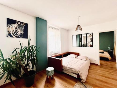 - une chambre avec un lit et une plante dans l'établissement Appartement cosy au centre-ville, à Haguenau