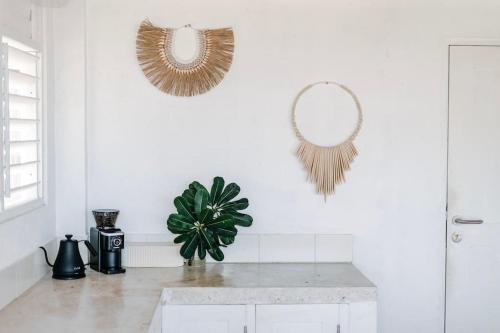a white kitchen with a mirror and a plant at Rote White House - South Villa & Loft in Nembrala