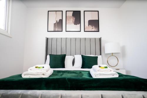 a bedroom with a green bed with towels on it at Renata's House in Bristol