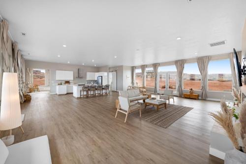 a large living room with white furniture and large windows at Page Arizona border town- Tranquil Zen Retreat with Amazing Mesa Views in Big Water