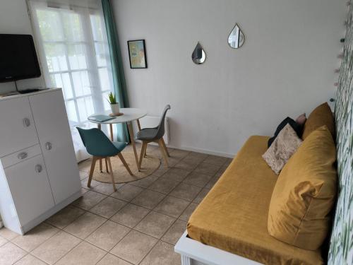 a living room with a couch and a table at Le petit jazz du lac in Marciac