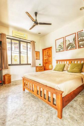 a bedroom with a large bed with a ceiling fan at Tropical Villa Koh Tao in Ko Tao