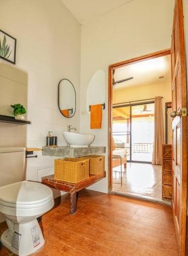 a bathroom with a toilet and a sink and a mirror at Tropical Villa Koh Tao in Ko Tao