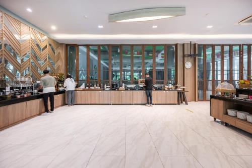 eine Lobby mit Menschen, die an einem Tresen in einem Restaurant stehen in der Unterkunft At Rice Resort in Nakhon Nayok