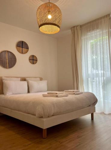 une chambre avec un lit, une fenêtre et un lustre dans l'établissement Résidence Services Séniors MONTANA CHARTRES, à Chartres