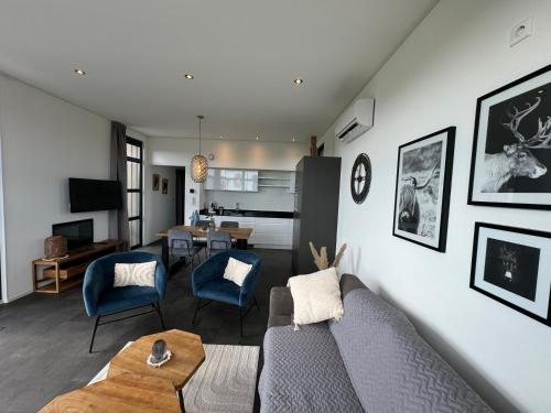 a living room with a couch and a table at Enkhuizer Strand Chalet Windrose mit Zaun Haus Nr 225 in Enkhuizen