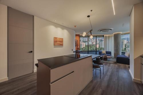 a kitchen and living room with a counter and a table at Nock - Reserved Residences in Medellín
