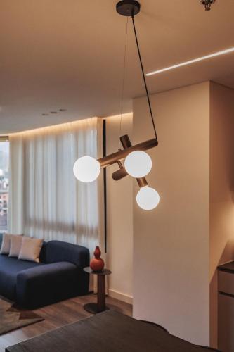 a living room with a blue couch and three lights at Nock - Reserved Residences in Medellín