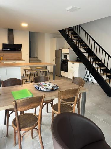 une cuisine et une salle à manger avec une table et des chaises dans l'établissement Camilette, à Labégude