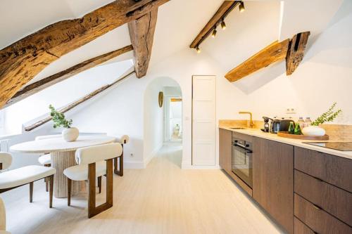 Il comprend une cuisine dotée de poutres apparentes, d'une table et de chaises. dans l'établissement 3 bedrooms Sacrée cœur Place du Tertre Montmartre, à Paris