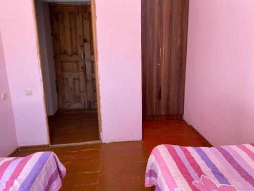 an empty room with two beds and a door at Villa QALDEA in Ushguli