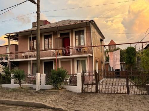 a pink house with a fence in front of it at Tazo's Guest House in K'obulet'i