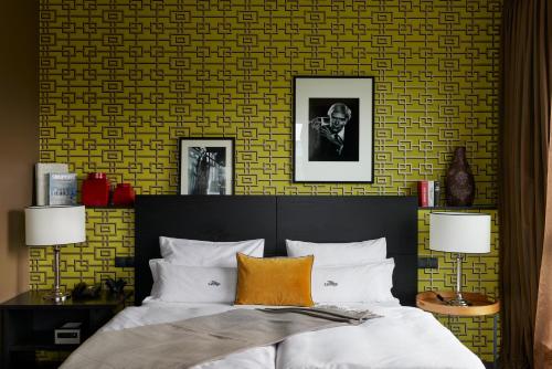 a bedroom with a bed and a yellow wall at The George Hamburg in Hamburg