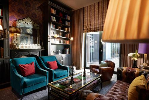 a living room with two blue chairs and a table at The George Hamburg in Hamburg