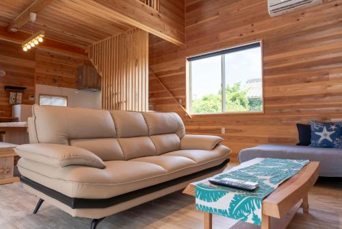 a living room with a leather couch and a table at Blu Pointe in Minamiboso