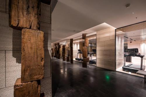 a gym with a row of exercise equipment on the wall at Luoyang Marriott Hotel in Luoyang
