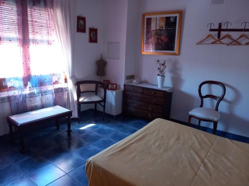 a bedroom with a bed and two chairs and a dresser at Cal Manyo in Puigvert de Lérida