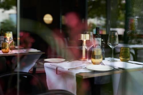 a table with wine glasses and plates on it at The George Hamburg in Hamburg