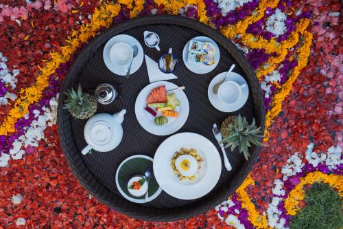een bord eten op een tafel met bloemen bij Happy Together By Kresna Hospitality in Seminyak