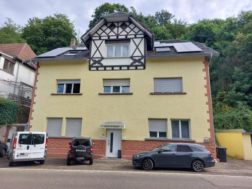 a yellow house with cars parked in front of it at Gästehaus Windheim (Ettlingen) in Ettlingen