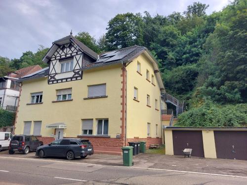 a yellow house with a clock on top of it at Gästehaus Windheim (Ettlingen) in Ettlingen