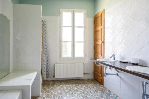 カプタングにあるVilla Domaine du Midi by Villa Plusの浴槽と洗面台と窓のあるバスルーム