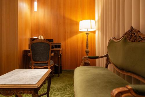 a room with a couch and a chair and a lamp at Inhouse Hotel Grand in Taichung