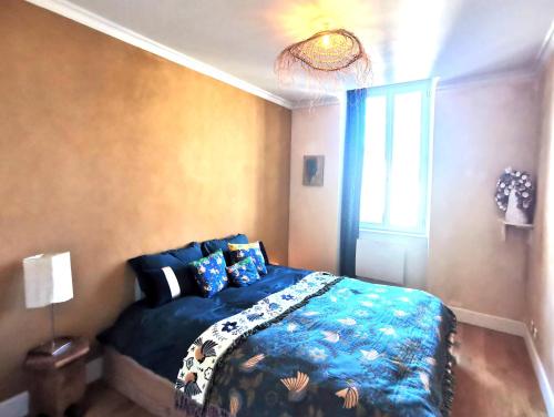 une chambre avec un lit avec une couette bleue dans l'établissement T2 Ambiance zen, hyper calme au coeur de Valence, à Valence