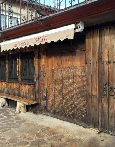 a wooden building with a bench in front of it at Hostal Cholo in Brañosera