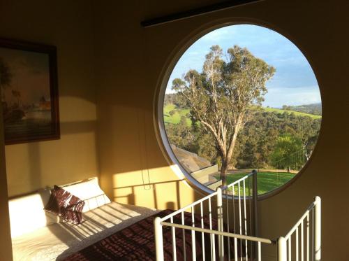 a bedroom with a large circular window and a bed at Sutherland Estate - Stunning Yarra Valley Vineyard in Dixons Creek