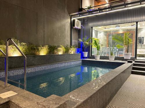 a swimming pool with plants in a building at Ganga Euphoria - A Luxury Villa on the Ganges in Rishīkesh