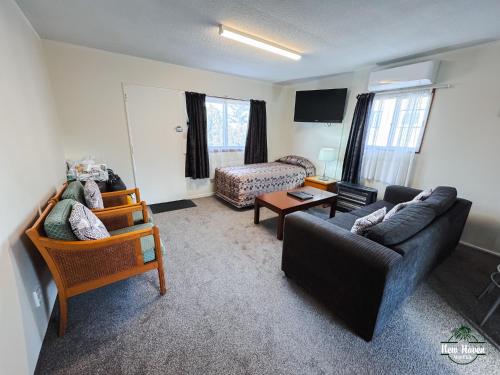 a living room with a couch and a chair at New Haven Motel in Auckland