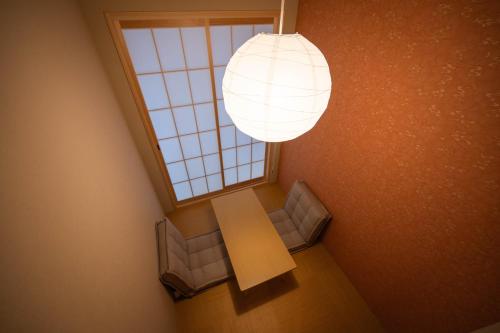 a room with a table and chairs and a window at 和居 宮羽 大阪の中心地にある伝統と現代が融合した和風一軒家貸切住居 in Osaka