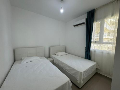 two beds in a room with a window at Caesar Resort & SPA - Apartment with 2 Bedroom - Aurelius in Saint Yeorgios