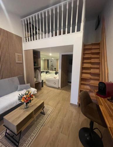 a living room with a couch and a staircase at Hôtel du Parc Canal - Stade de France in Saint-Denis