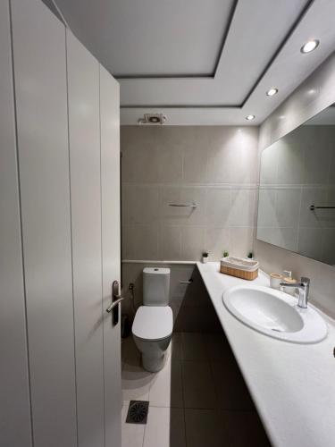 Un baño blanco con inodoro y lavabo. en Galazio, en Naxos Chora
