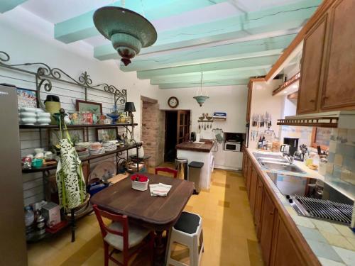 une cuisine avec une table en bois et une salle à manger dans l'établissement Maison en pierre dans la forêt - piscine & calme, à Martel