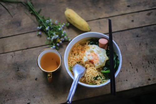 Sapa Jungle Homestay في سابا: وعاء من الحساء وكوب من الشاي على الطاولة